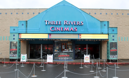 Exterior of Three Rivers Cinemas with a colorful marquee and queue barriers in front.
