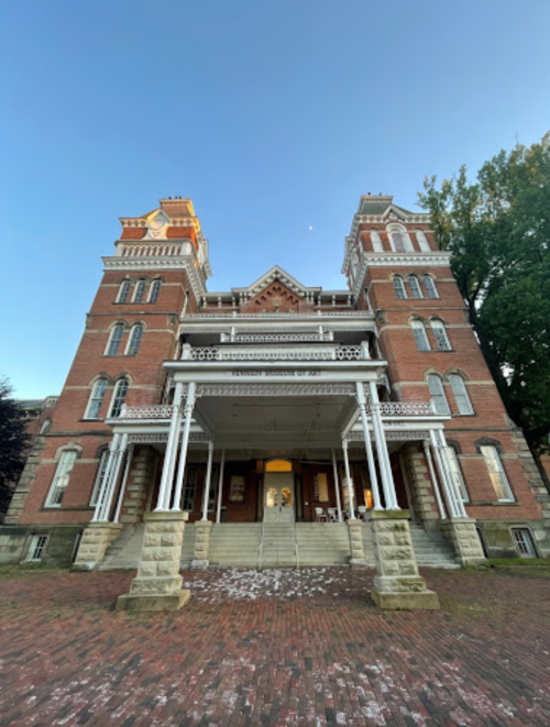 Historic brick building with a grand entrance, featuring multiple stories and decorative architectural details.