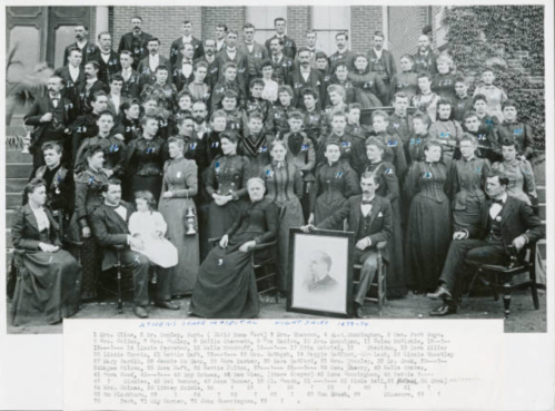 A large group portrait of students and staff from a school, taken in 1877-78, with names listed below the image.