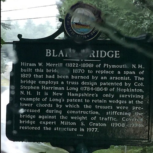 Sign about Blanch Bridge, detailing its history and design, partially obscured by rain on the glass.