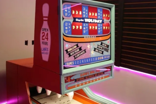 A colorful bowling-themed arcade game with a digital score display and neon lighting.
