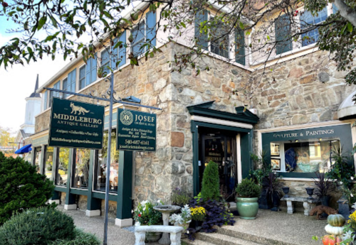 Exterior of a stone building featuring antique galleries, with signs for Middleburg Antique Gallery and Josef's Sculpture & Paintings.