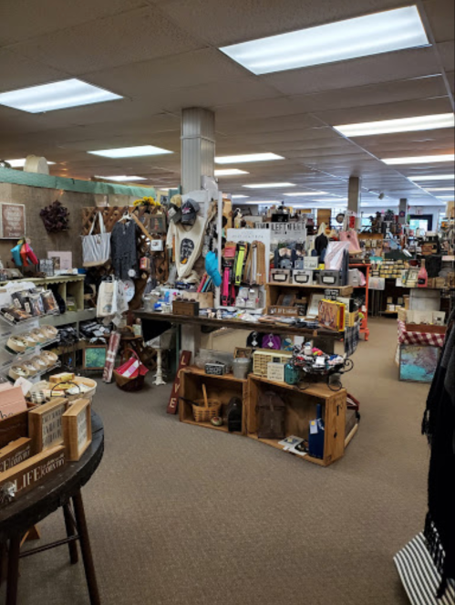 A spacious store interior filled with various home decor items, crafts, and wooden displays. Brightly lit and inviting.