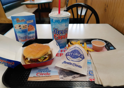 A tray with a burger, fries, a shake, and fry sauce at Arctic Circle restaurant.