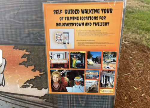 Sign for a self-guided walking tour of filming locations for "Halloweentown" and "Twilight," featuring QR codes and images.