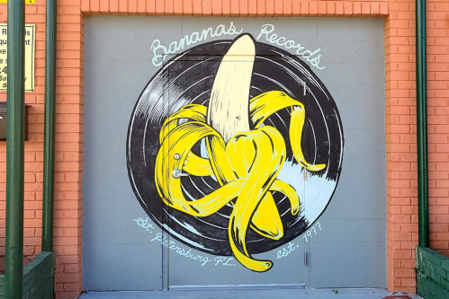 Colorful mural of a banana on a vinyl record, featuring "Bananas Records" and "St. Petersburg, FL" established 1997.