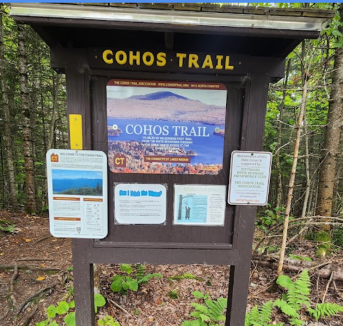 Signpost for Cohos Trail surrounded by trees, featuring maps and information about the trail.