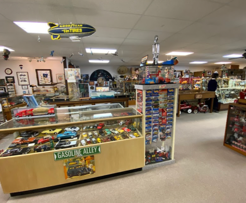 A vintage store interior featuring model cars, memorabilia, and a display of collectibles in a cozy setting.