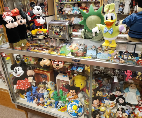A display case filled with various vintage toys and collectibles, including Disney characters like Mickey and Donald Duck.