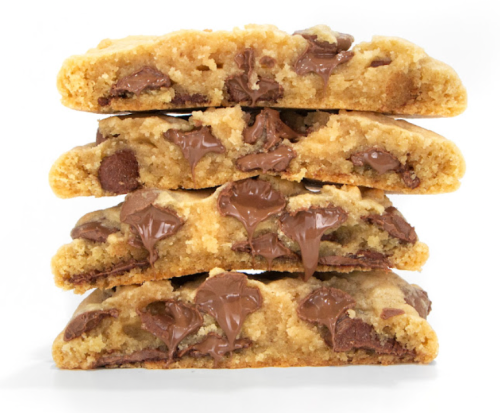 A stack of four chocolate chip cookies, showing gooey chocolate chunks and a soft, chewy texture.