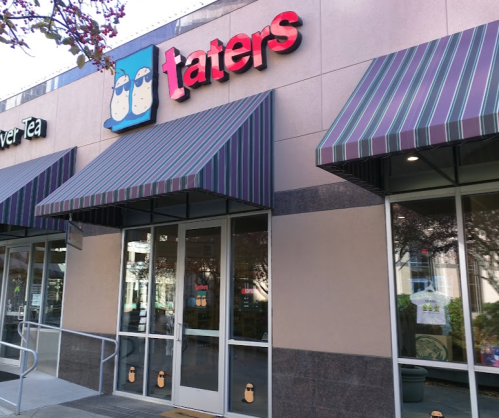 Exterior of a store named "taters" with striped awnings and a welcoming entrance.