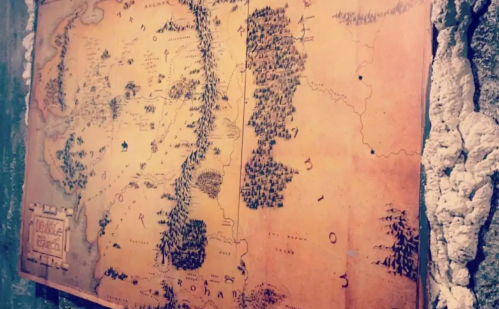 A vintage-style map depicting a fantasy landscape with regions like Rohan and Gondor, featuring mountains and forests.