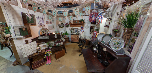 A cozy vintage garden-themed display with decor, furniture, and floral arrangements in a charming setting.