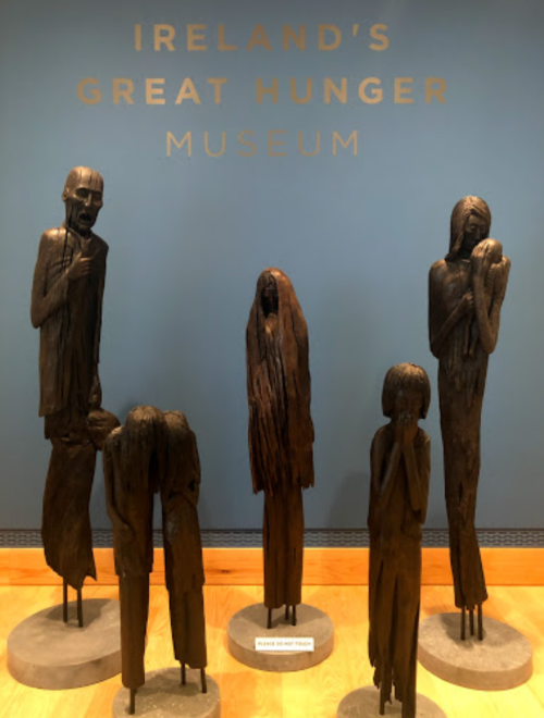 Five wooden sculptures depicting figures in distress, displayed at Ireland's Great Hunger Museum.