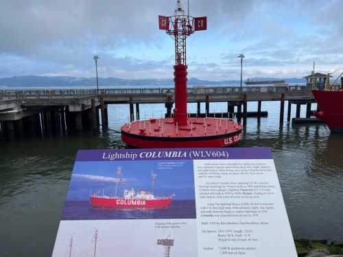 A red lightship named Columbia (WLV604) docked near a pier, with informational signage in the foreground.