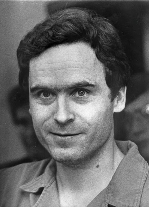 A black and white portrait of a man with dark hair and a slight smile, wearing a collared shirt.