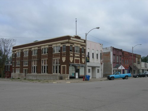 A street view of several old buildings, showcasing brick and plaster facades under a cloudy sky.