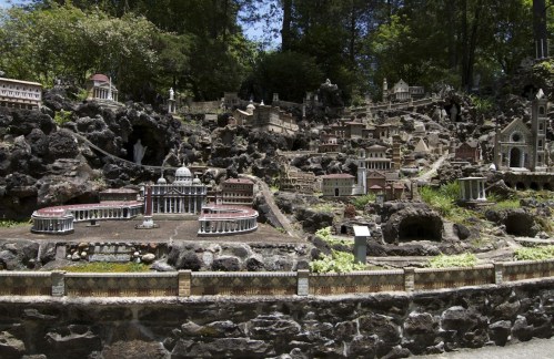 A detailed miniature landscape featuring various architectural structures set among rocks and greenery.