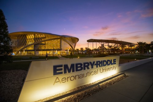 Embry-Riddle Aeronautical University sign at sunset, showcasing modern architecture and vibrant sky colors.