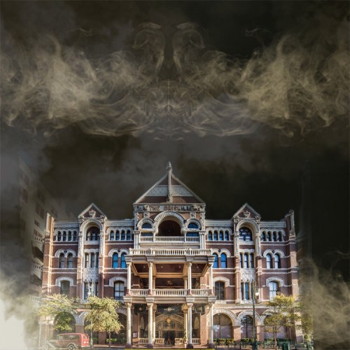 A historic building shrouded in mist, featuring intricate architecture and a dramatic, eerie atmosphere.