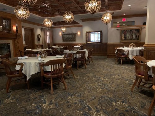 Elegant restaurant interior with wooden furniture, decorative lighting, and a cozy atmosphere.