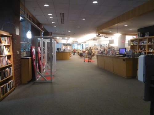 A spacious bookstore interior with shelves of books, a checkout counter, and customers browsing.