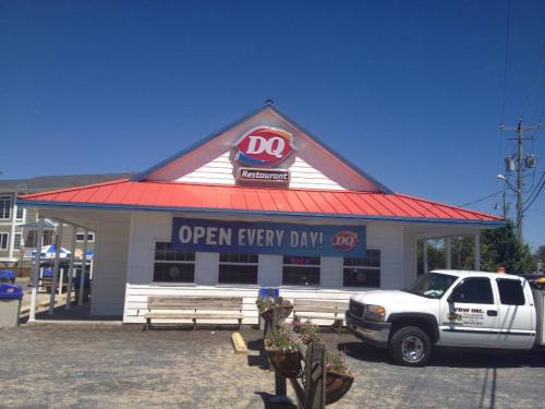 A Dairy Queen restaurant with a red roof and a sign that says "Open Every Day" against a clear blue sky.
