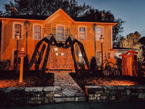 A spooky house decorated for Halloween, featuring a large spider web and eerie lighting.