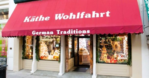 A storefront with a red awning reading "Käthe Wohlfahrt" and "German Traditions," featuring festive window displays.