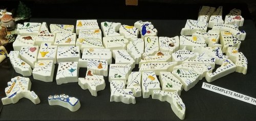 A colorful, artistic map of the United States made from ceramic pieces, each labeled with state names and symbols.
