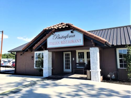 Exterior of Pastafina Italian Restaurant, featuring a tiled roof and a welcoming entrance on a sunny day.