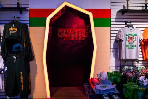 A vibrant display featuring "Stranger Things" merchandise and a glowing entrance shaped like a portal.