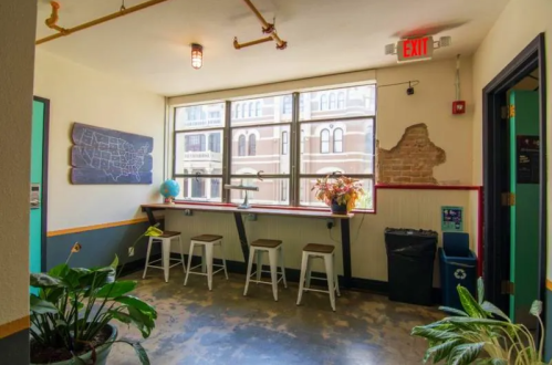 Bright, inviting room with a window, bar seating, plants, and a chalkboard on the wall.