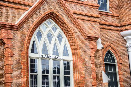 Close-up of Clark Hall's brick facade, featuring arched windows and intricate architectural details.