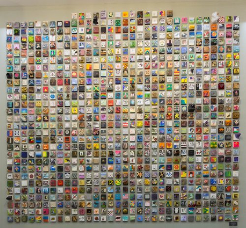 A colorful mosaic of small square tiles, each featuring unique designs and patterns, arranged in a grid format.