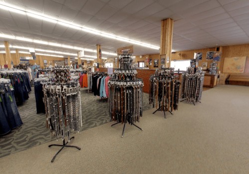 A spacious retail store featuring racks of clothing and displays of various tools and equipment.