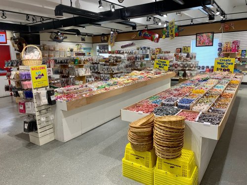 A colorful candy store interior with various candy displays and a "Create Your Own Mix" sign.