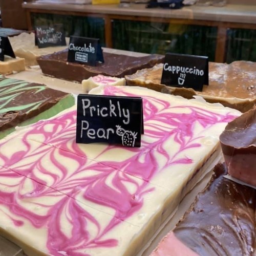 Colorful fudge display with flavors labeled: Prickly Pear, Chocolate, Cappuccino, and Maple Walnut.