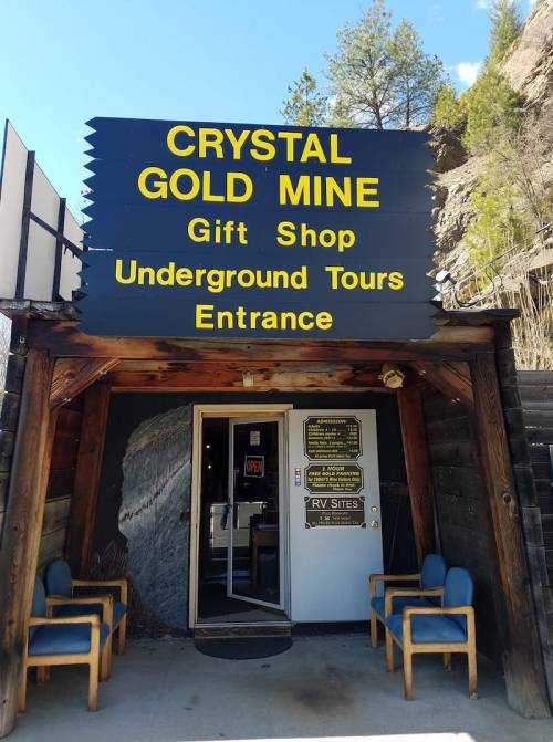 Entrance to the Crystal Gold Mine featuring a gift shop and underground tours, with chairs outside.