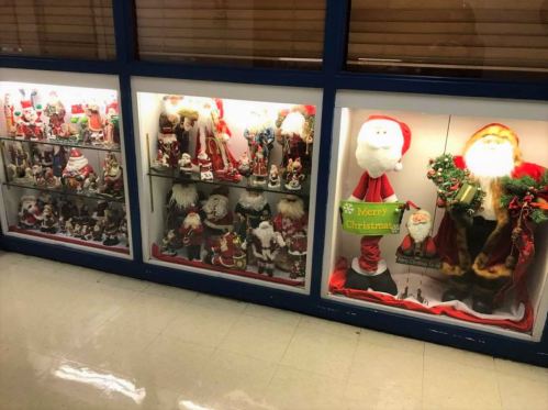 Display case filled with various Santa Claus figurines and decorations for Christmas.