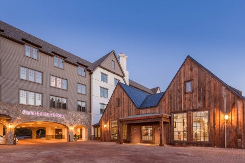 Exterior view of a hotel featuring a mix of modern and rustic architecture at dusk.