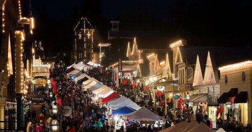 A bustling night market with colorful tents, festive lights, and a crowd enjoying the lively atmosphere.