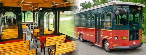 A vintage-style trolley bus with wooden benches, featuring a green and red exterior, parked beside an empty interior.