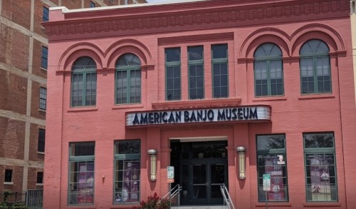Exterior of the American Banjo Museum, featuring a pink facade and large arched windows.