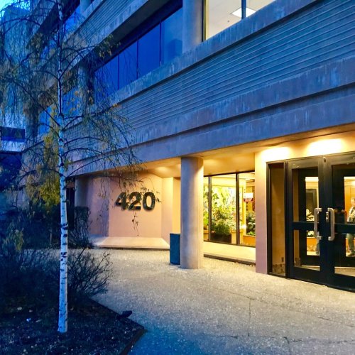 Exterior view of a building with the number "420" displayed, featuring large windows and a welcoming entrance.