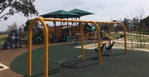 A colorful playground featuring swings, slides, and climbing structures on a sunny day.