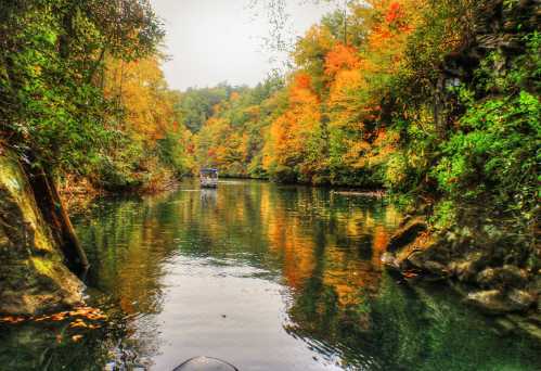 A serene river surrounded by vibrant autumn foliage, reflecting colorful trees in calm waters.