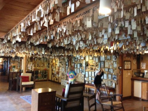 A room filled with hanging tags and framed photos, with two people exploring the space.