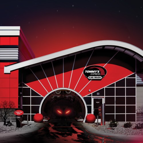 A modern car wash building with a red and black design, featuring a large entrance and the sign "Tommy's Express Car Wash."