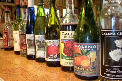 A row of wine bottles with colorful labels, showcasing various flavors from Galena Cellars.
